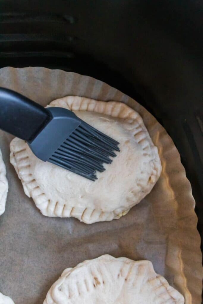 breakfast bomb sandwich in air fryer being brushed