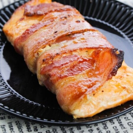 bacon wrapped salmon on black plate