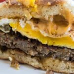 Blackstone Breakfast Sandwich sliced in half sitting on plate