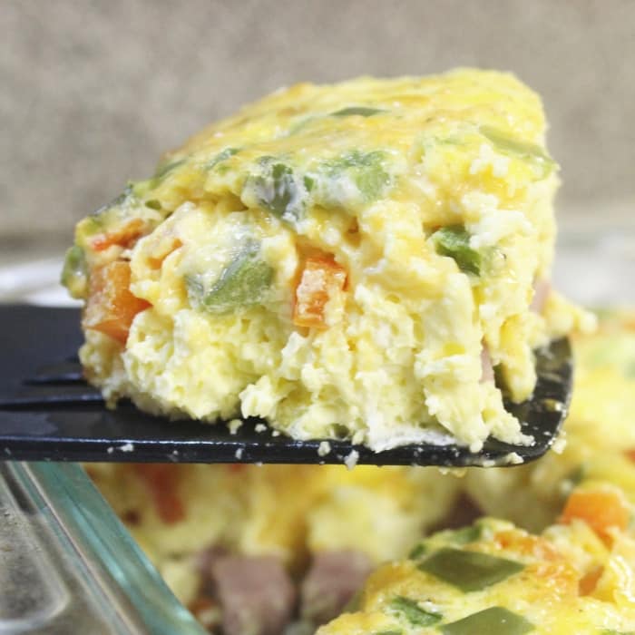Serve up this baked western omelette for breakfast, lunch, or dinner! Easy prep, and within no time you have a fluffy egg omelet baked in the oven. #western #denver #omelette #easy #baked #casserole #peppers #cheese #breakfastcasserole #recipe #ham #bake #simple #Athome #lunch #healthy breakfast omelette scooped out of pan