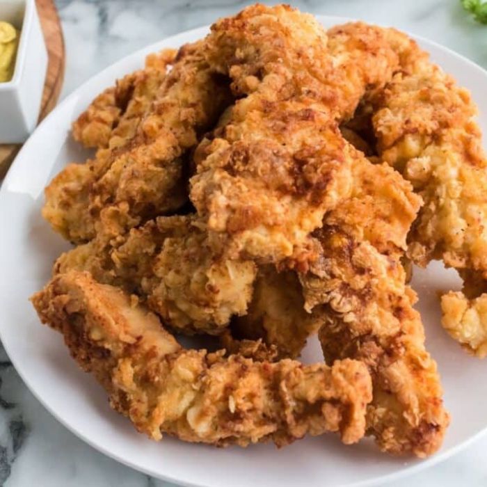 Homemade Chicken Strips on a plate stacked on top of one another