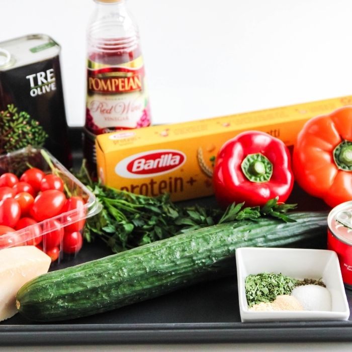 ingredients for pasta salad on a baking sheet