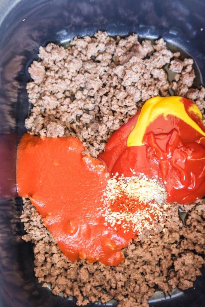 ground beef and spices and sauce in a crockpot