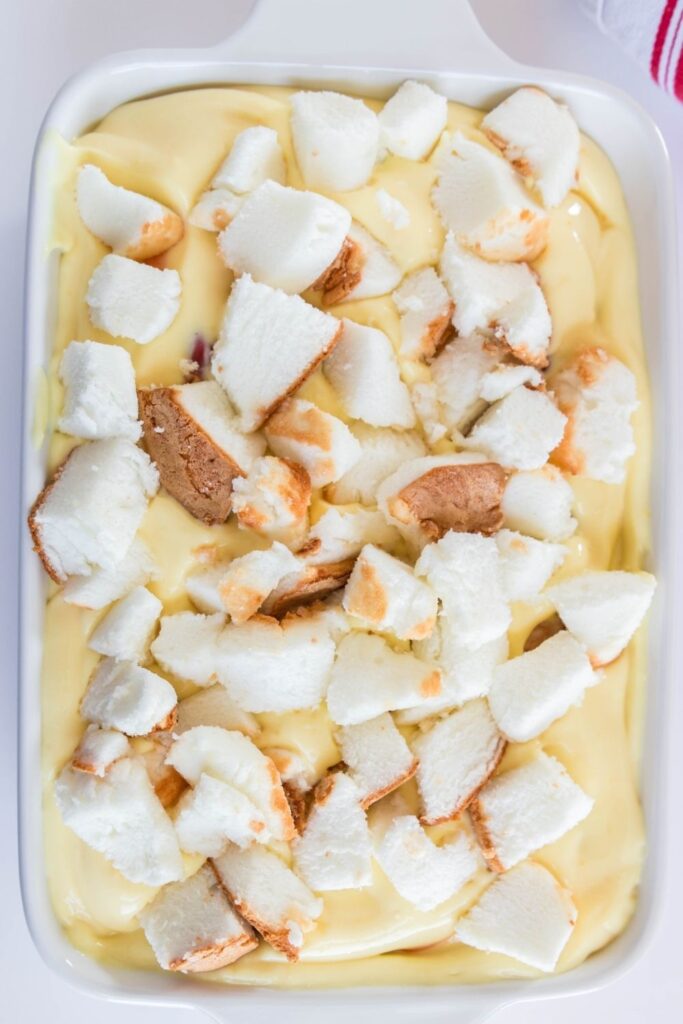 cool whip dessert with angel food cake on top of pudding in pan