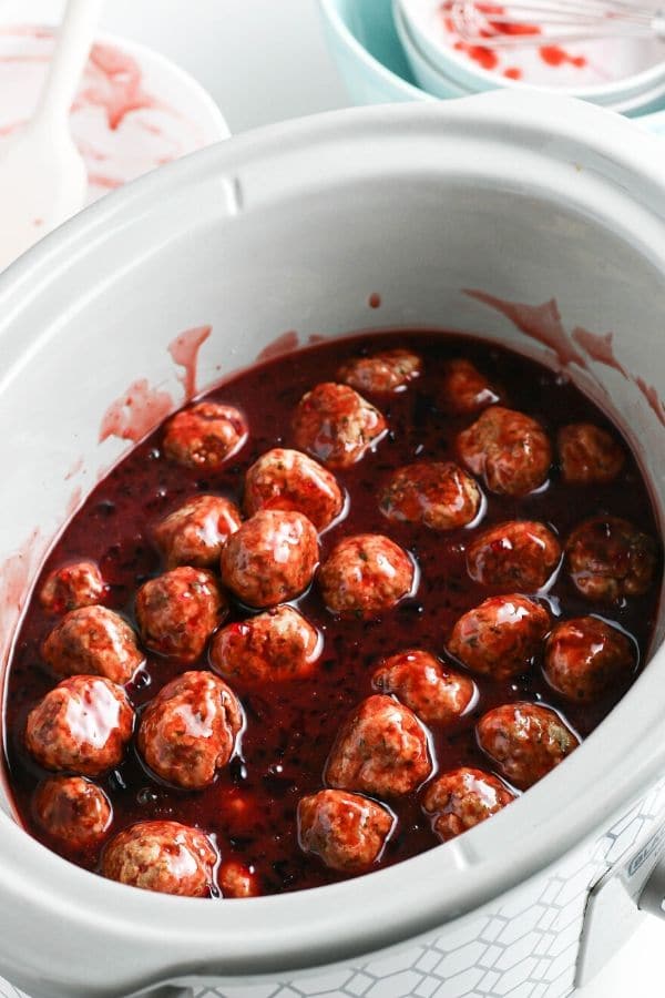 side view of a crockpot full of grape jelly meatballs