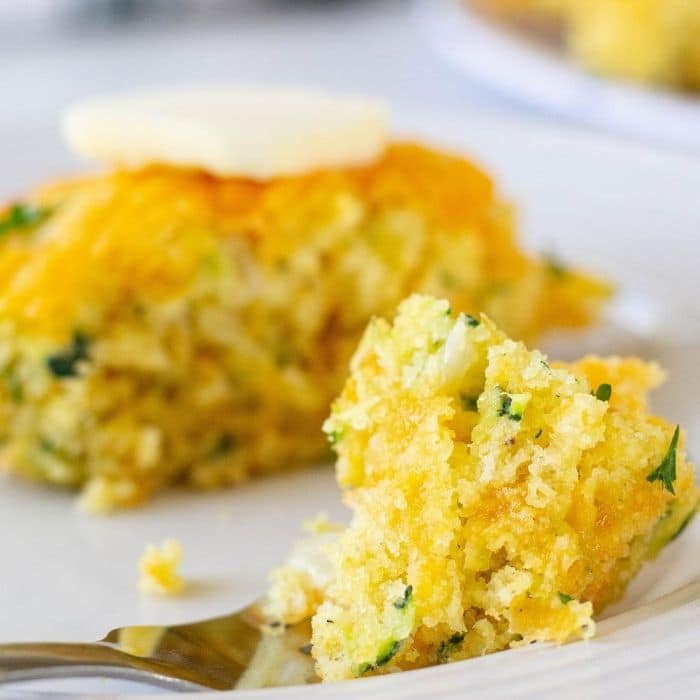 zucchini cornbread on a plate with a bite on a fork