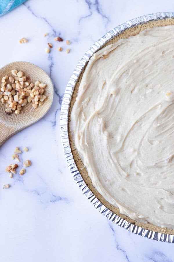 peanut butter pie on marble counter with nuts by it