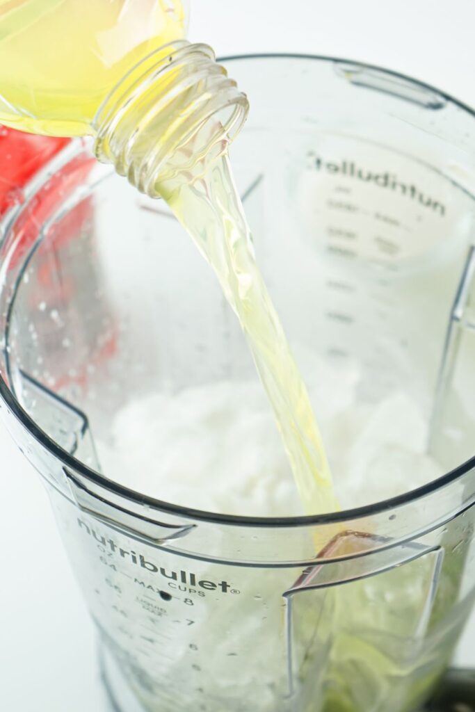 pouring gatorade into a mixer with ice in it
