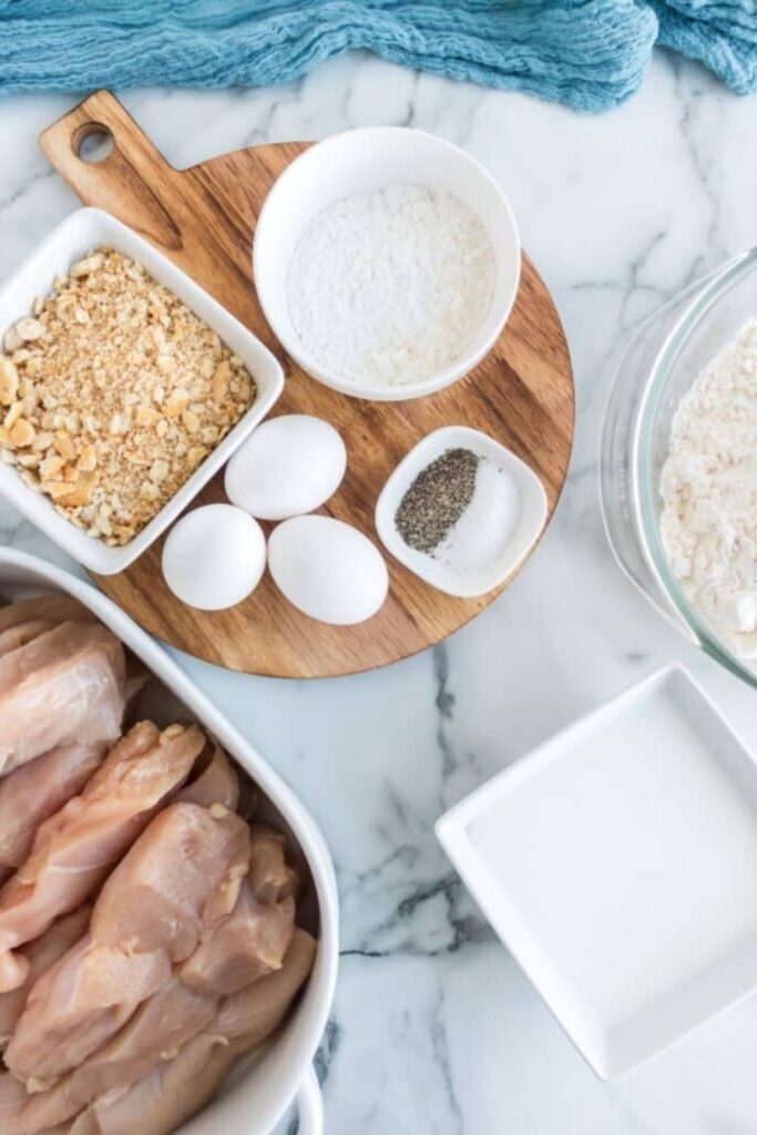 ingredients for homemade chicken strips on table in single serve bowls to show each ingredient