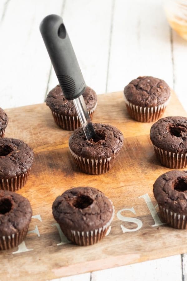 homemade chocolate cupcakes getting cored out