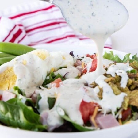salad with dressing being drizzled on top