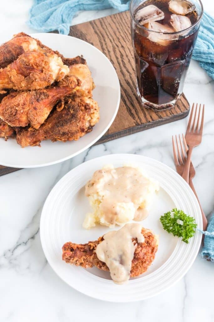 Fried Chicken Legs on plate with a plate in front with one leg and mashed potatoes