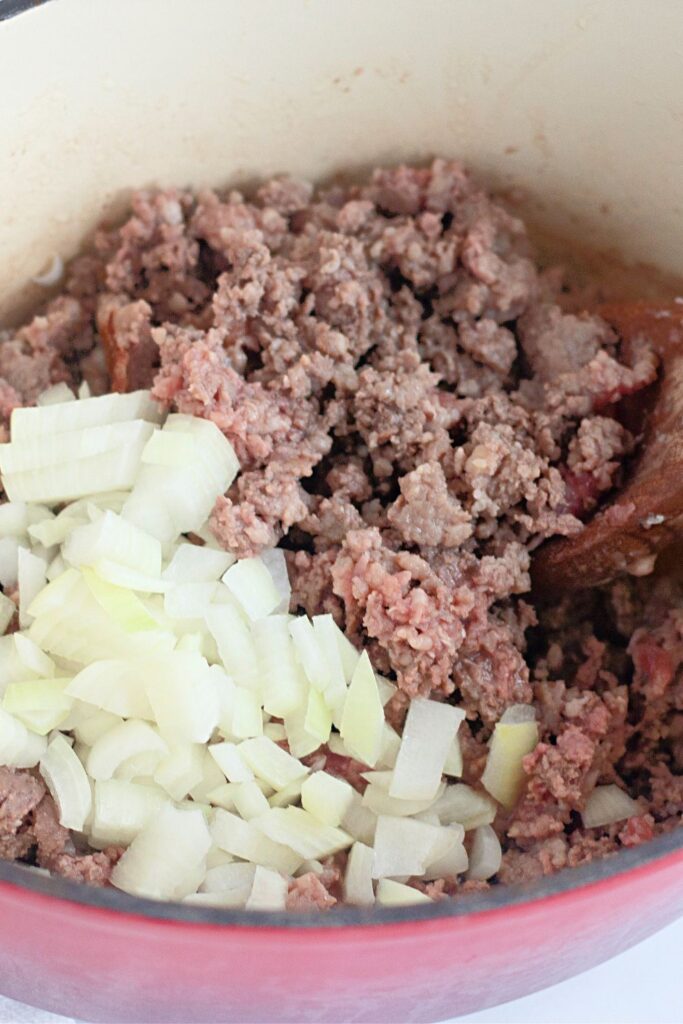 meat cooked in a Dutch oven with onion on side of pan