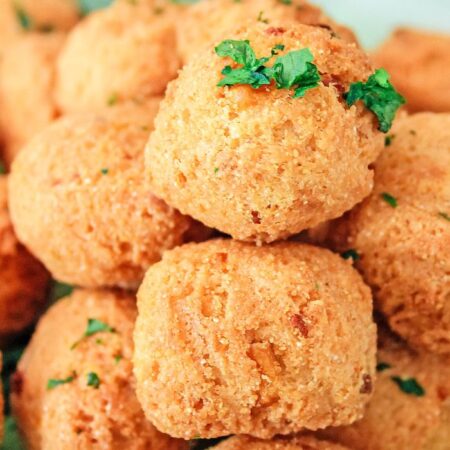 hush puppies stacked on a plate with parsley on top