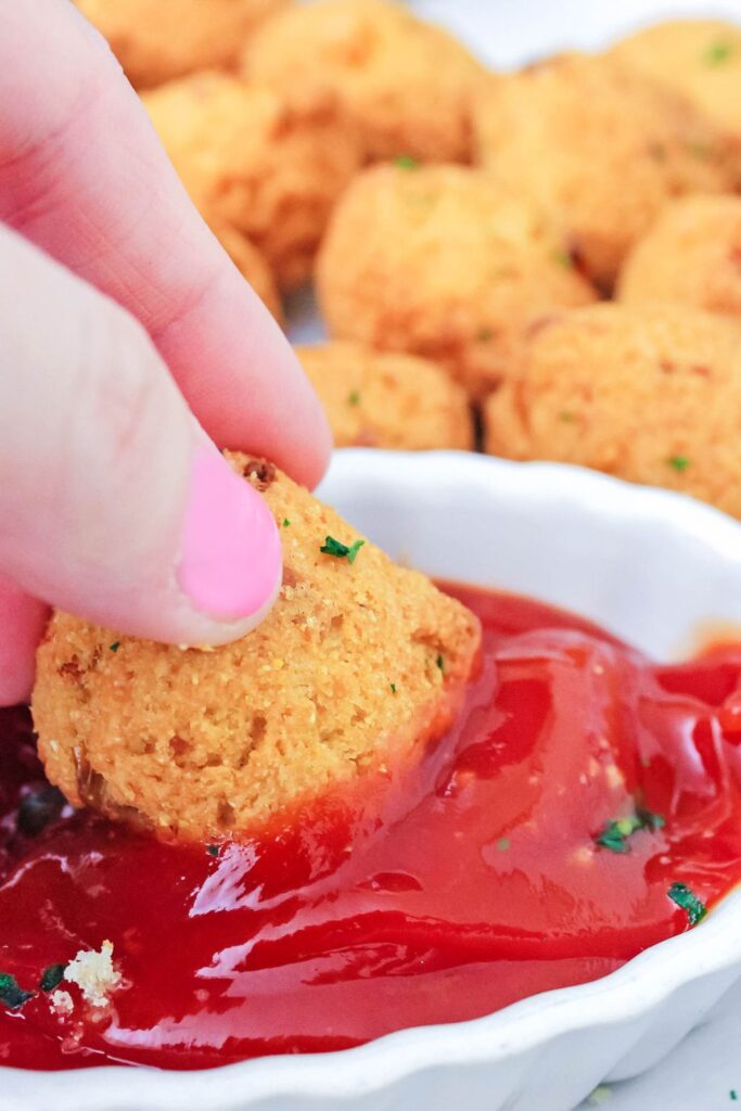 hush puppy dipped in ketchup