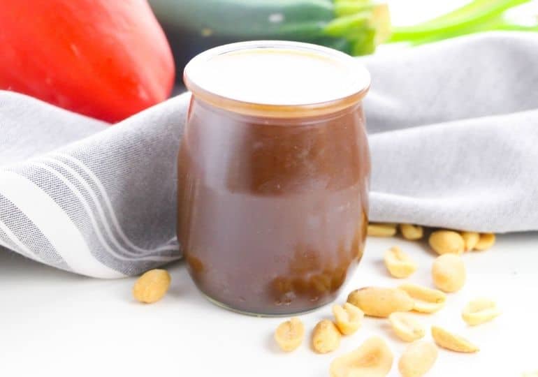 Kung Pao sauce in a jar with nuts around it