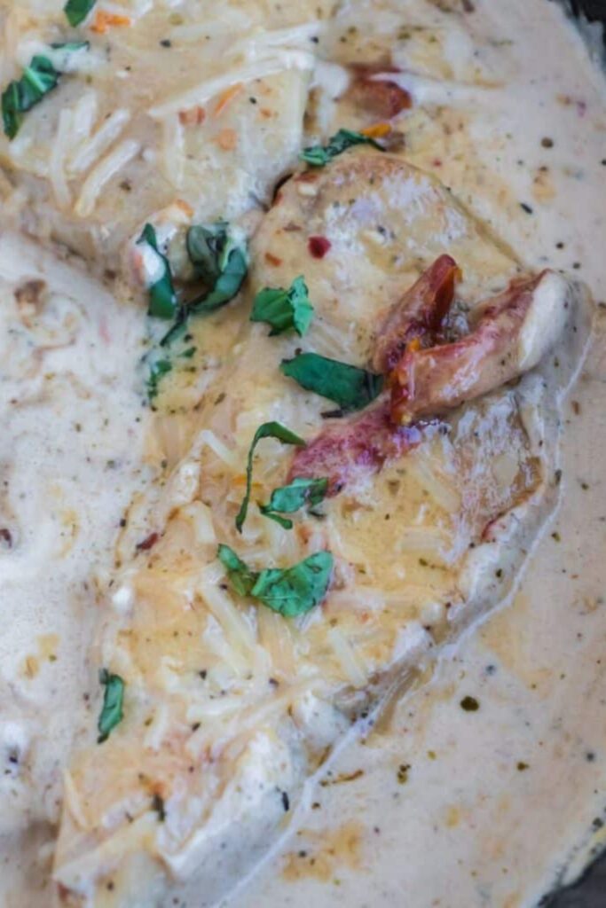 marry me chicken smothered in a creamy sauce in a cast iron skillet