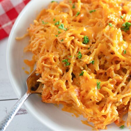 white plate with chicken spaghetti on it with a fork on it