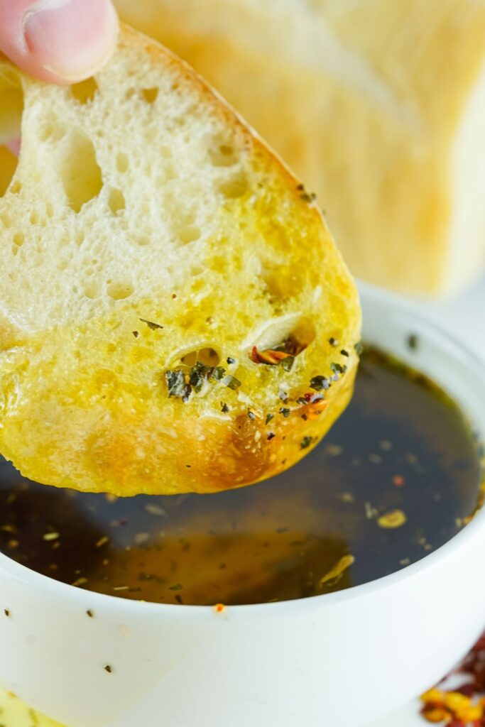 bread dipping into oil dip in a bowl