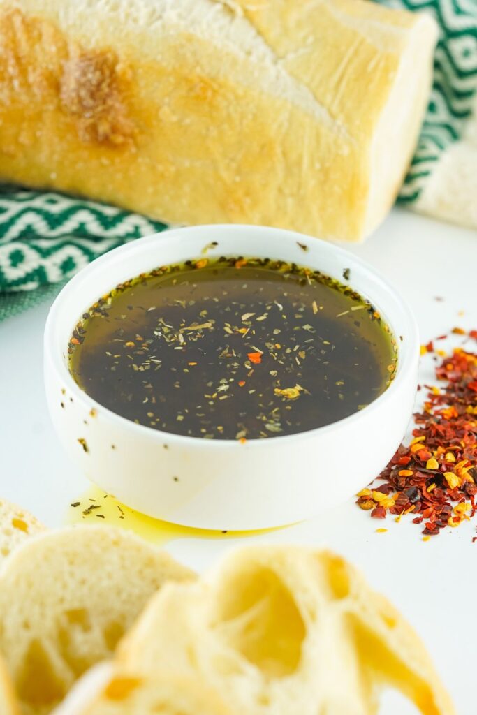 bowl of olive oil dip with bread sliced around it