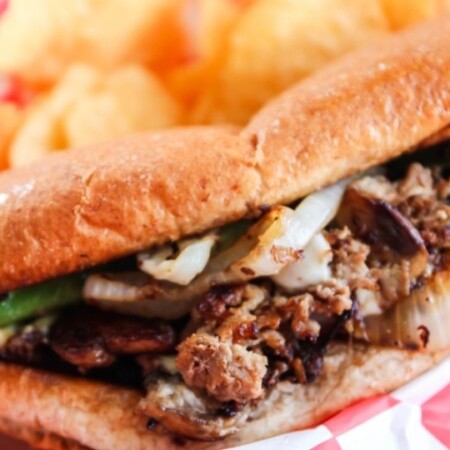philly cheesesteak in a basket with chips by it