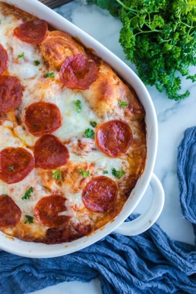 pizza bubble bread in a round casserole dish with parsley on the side