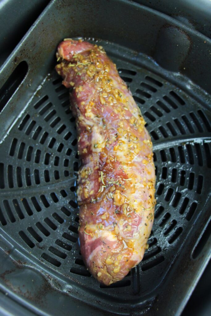 raw Marinated Pork Tenderloin in an air fryer basket