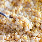 creamy corn in a plate with a spoon full of cream corn