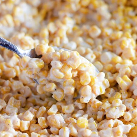 creamy corn in a plate with a spoon full of cream corn