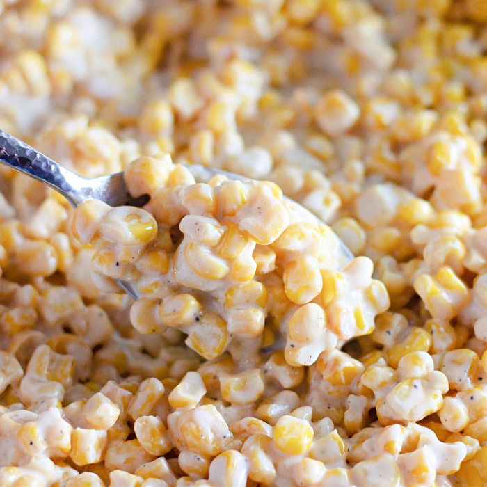 creamy corn in a plate with a spoon full of cream corn