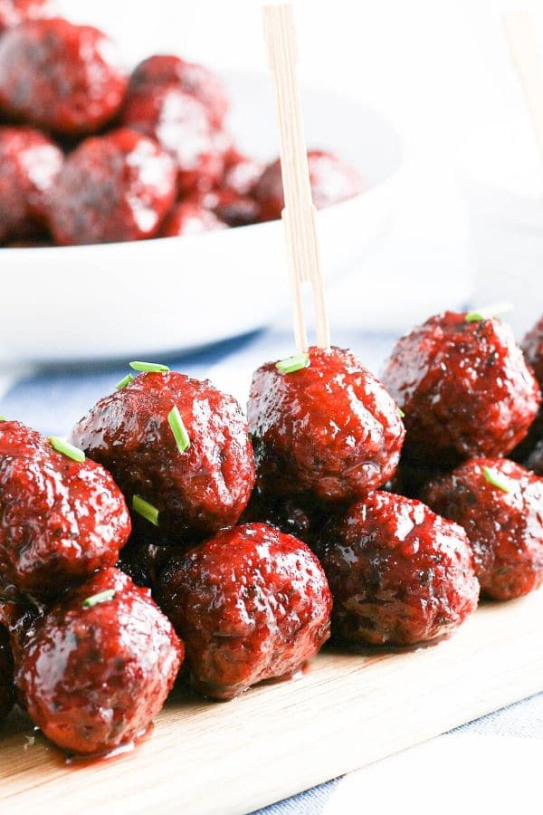 side view of meatballs with garnish on top stacked on tray