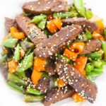 stir fry on a plate topped with sesame seeds