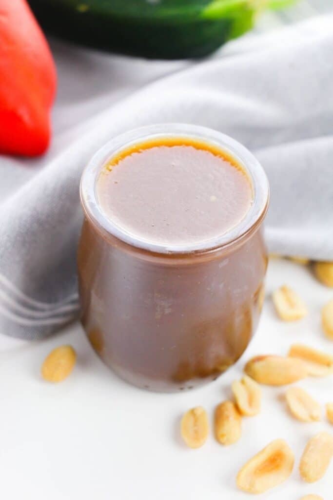 jar with chinese stir fry sauce and nuts around