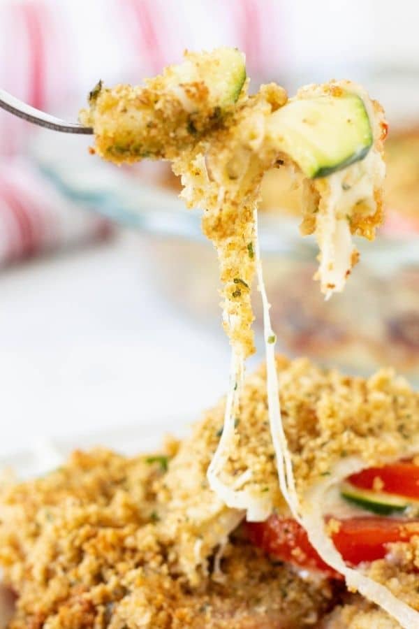 lifting up zucchini pie from pan with cheese pull