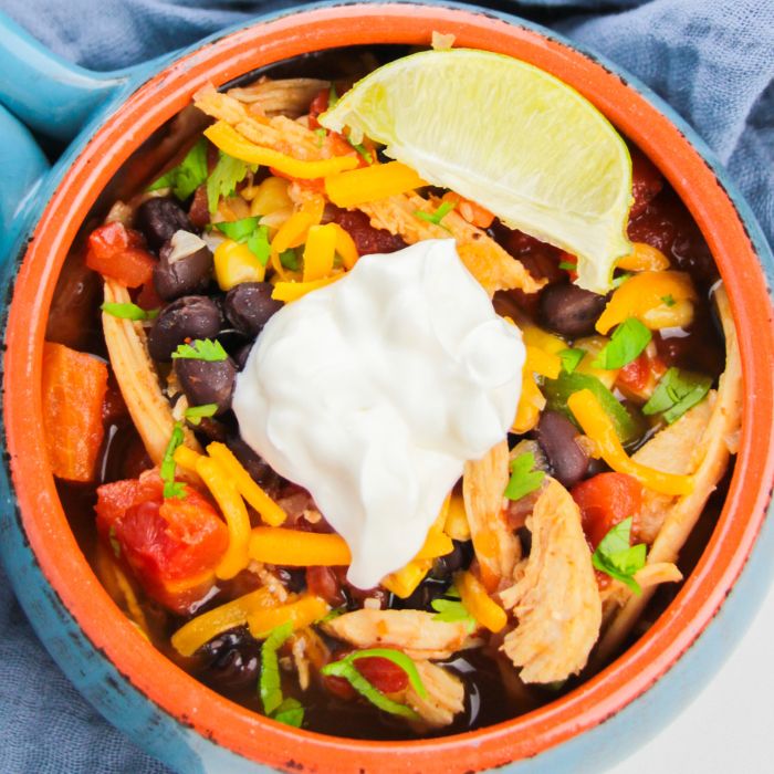 chicken tortilla soup in a bowl with toppings on top
