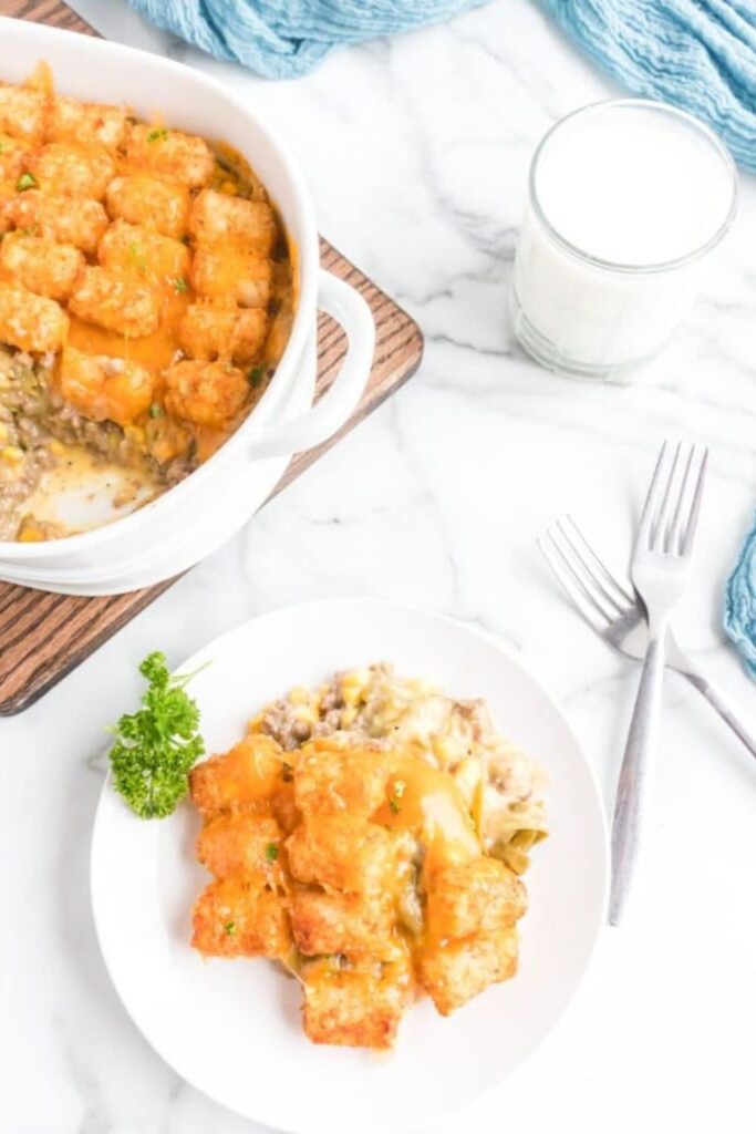 tater tot casserole on a plate and the rest of the pan on table behind the plate