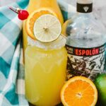 tequila orange juice on table with towel behind it