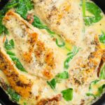 Tuscan Chicken in a pan with sauce and spinach on it