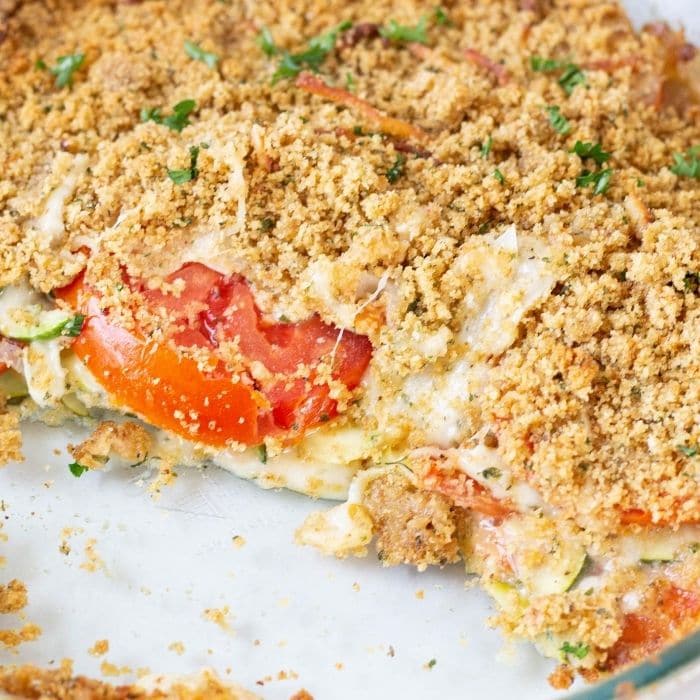 zucchini casserole in a glass dish with some scooped out